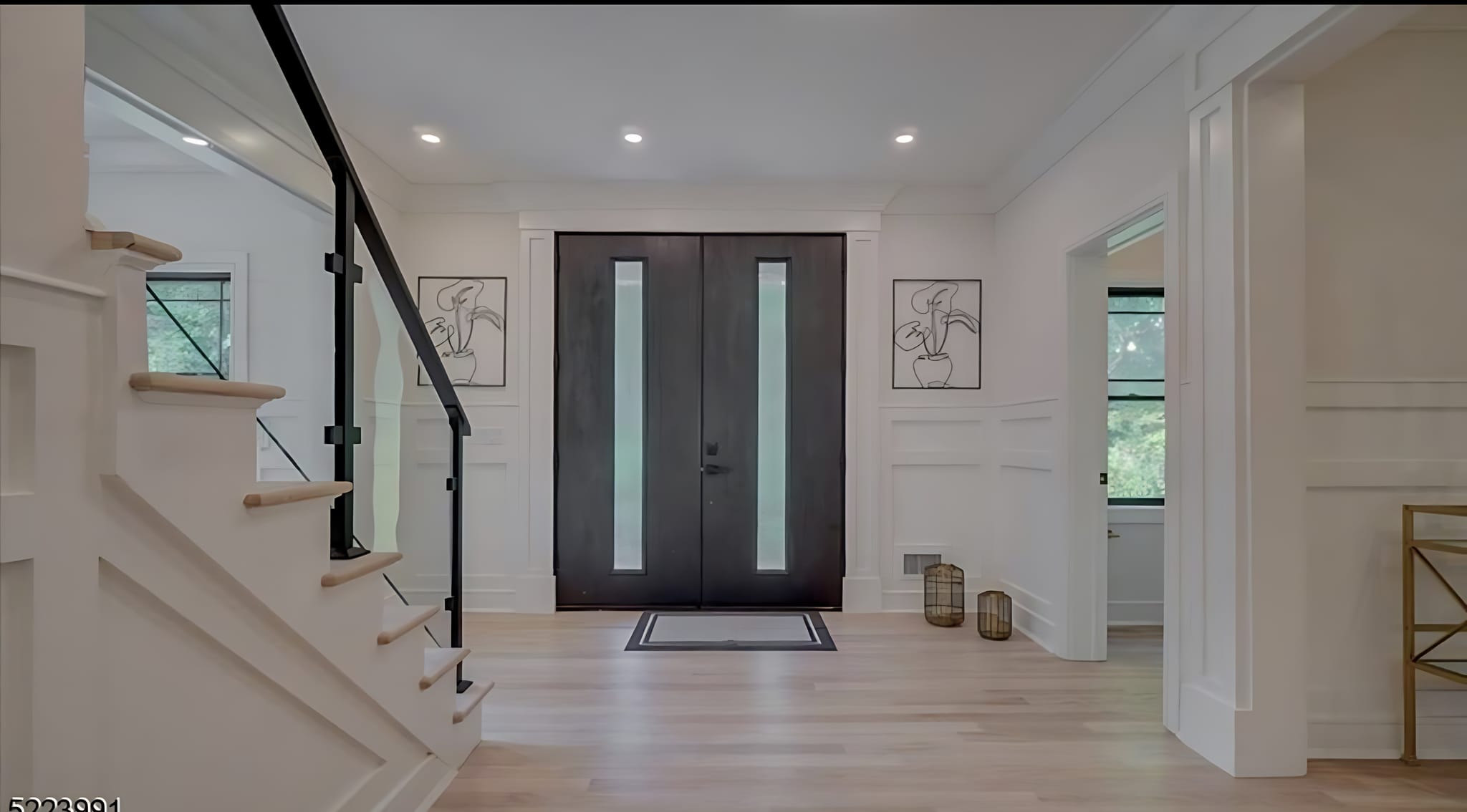 Modern foyer with glass railing staircase and double doors