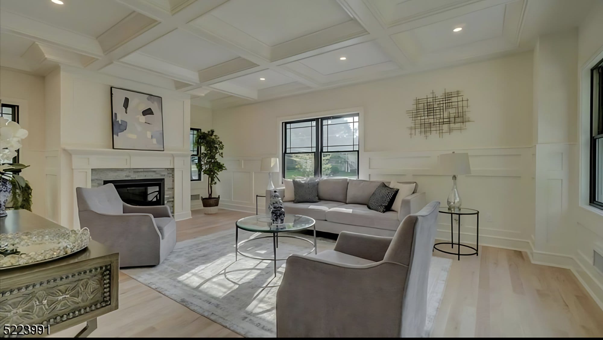 Staged living room with coffered ceiling and fireplace
