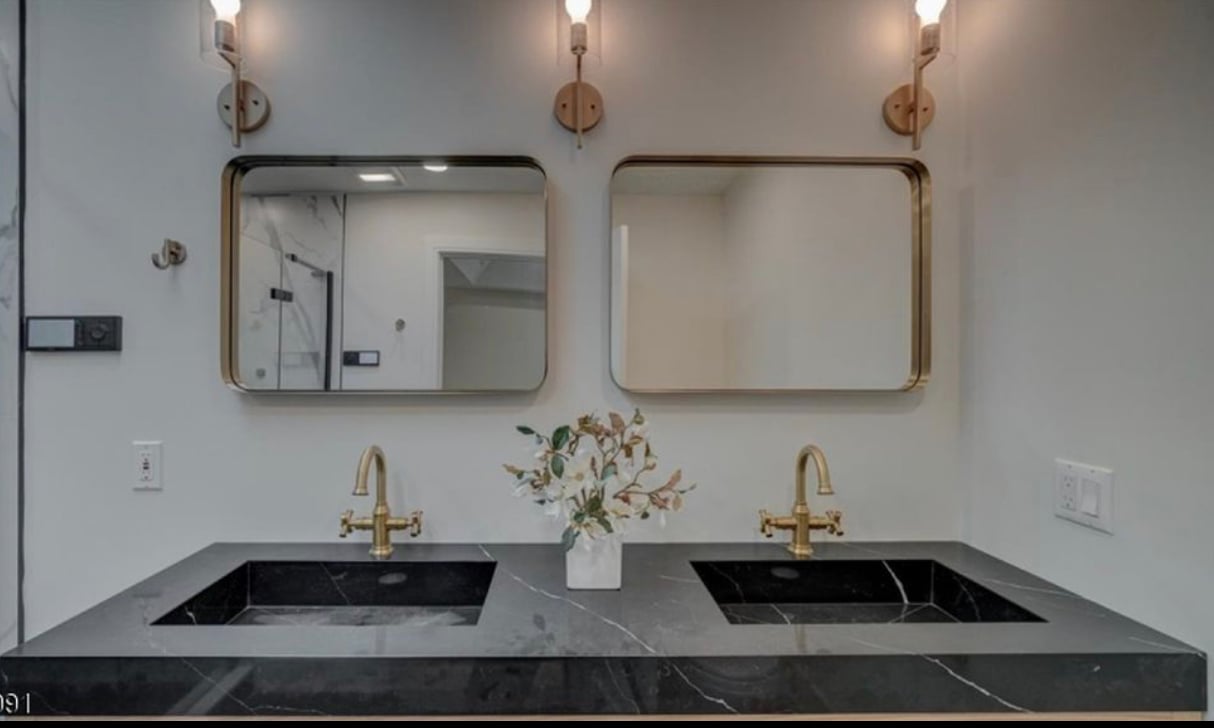 Black marble vanity with brass fixtures