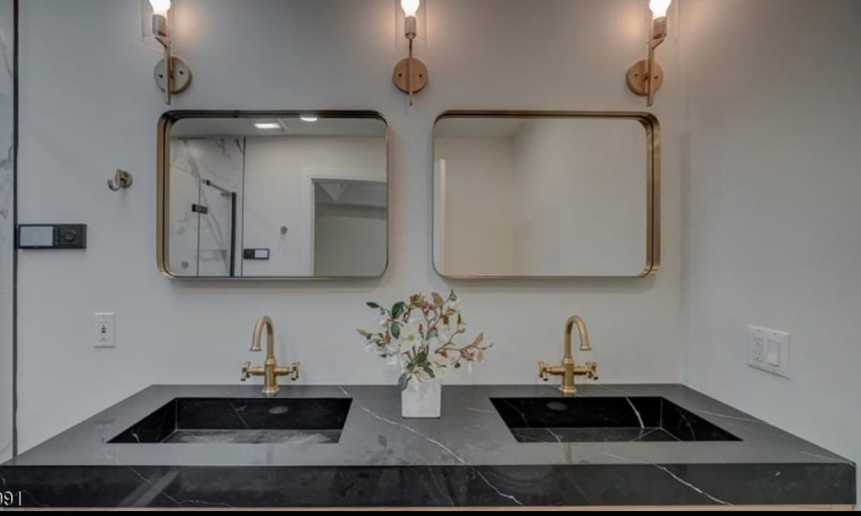 Black marble vanity with brass fixtures